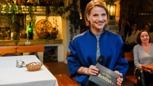 Moderatorin Kristina Sprenger mit einem goldenen Pokal auf dem der Schriftzug "Die goldene Reblaus" eingraviert ist