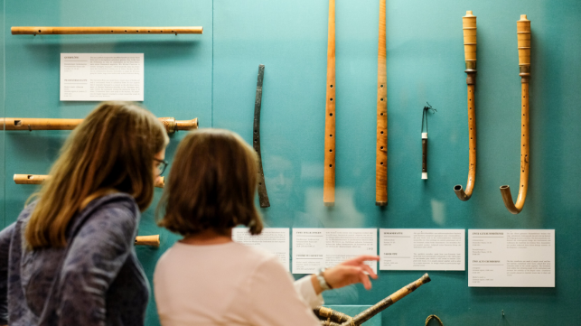 Zwei Frauen stehen vor einer Vitrine mit Ausstellungsstücken