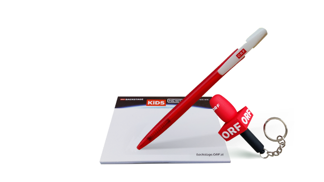 Ein ORF-Haftnotizblock mit ORF-Kugelschreiber und einem Mikrofon-Schl&uuml;sselanh&auml;nger sind vor wei&szlig;em Hintergrund arrangiert